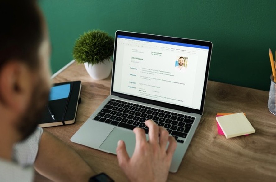 Profissional analisando tela de computador com interface de plataforma de recrutamento com IA