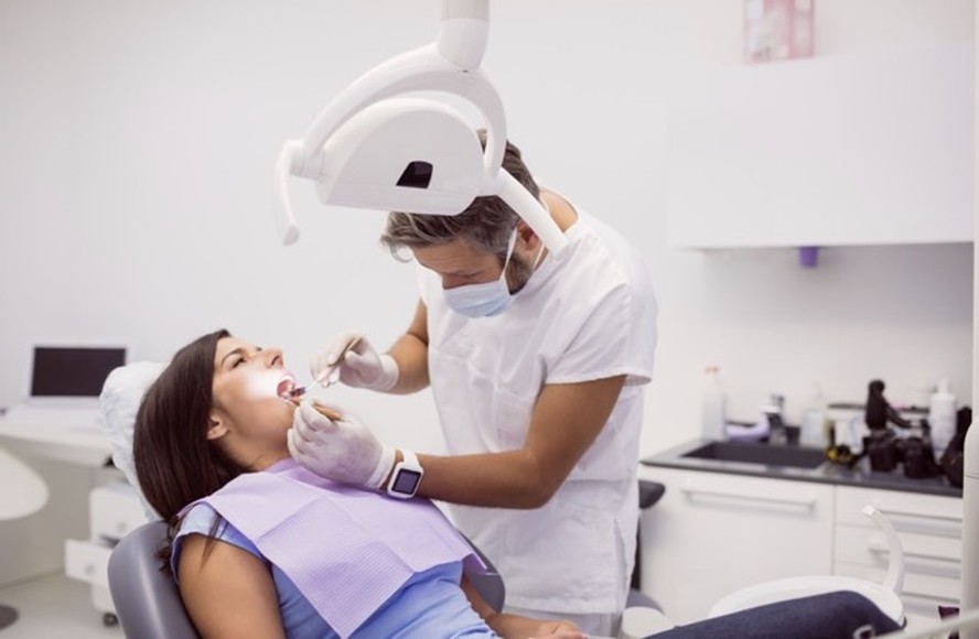 Profissional dentista atendendo paciente em consultório moderno