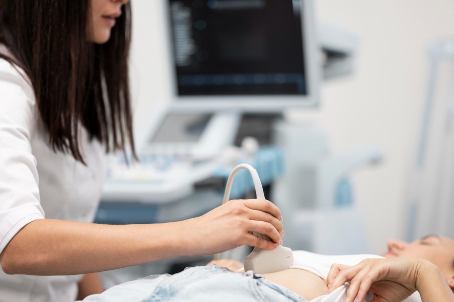 Médico realizando exame de ultrassom pélvico em consultório
