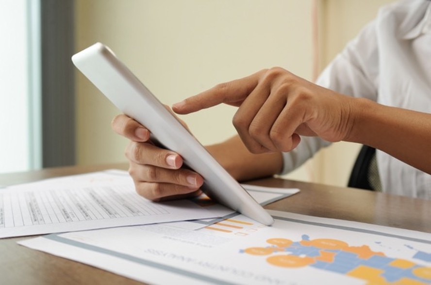 Profissional analisando documentos digitais em tablet durante processo de admissão