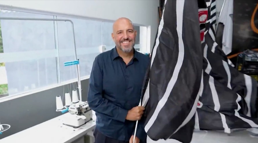 Empresário mostrando bandeira gigante de torcida organizada
