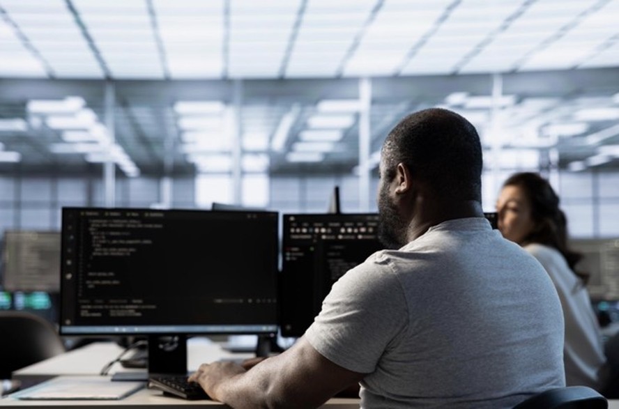 Profissional trabalhando com tecnologia em ambiente corporativo moderno