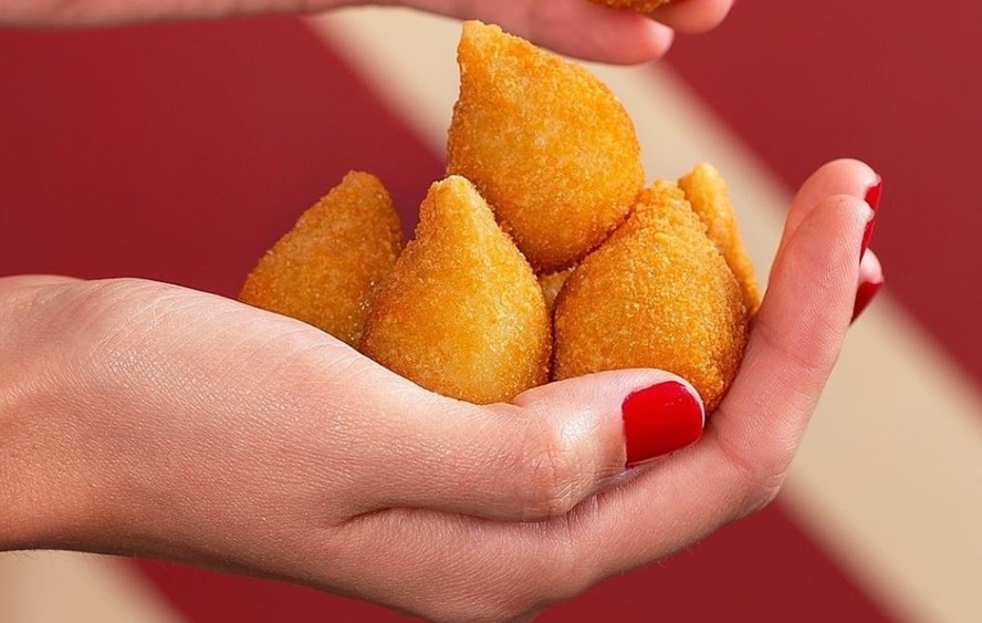Ragazzo lan a coxinhas com recheio de feijoada moqueca e pernil