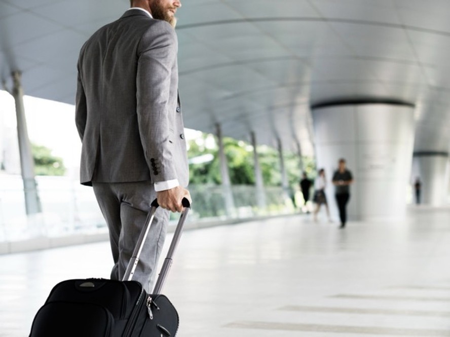 Executivo analisando dados de viagens corporativas em tablet