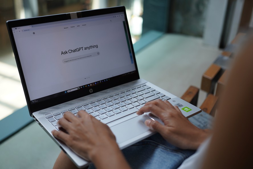 Profissional brasileiro trabalhando com inteligência artificial em escritório moderno
