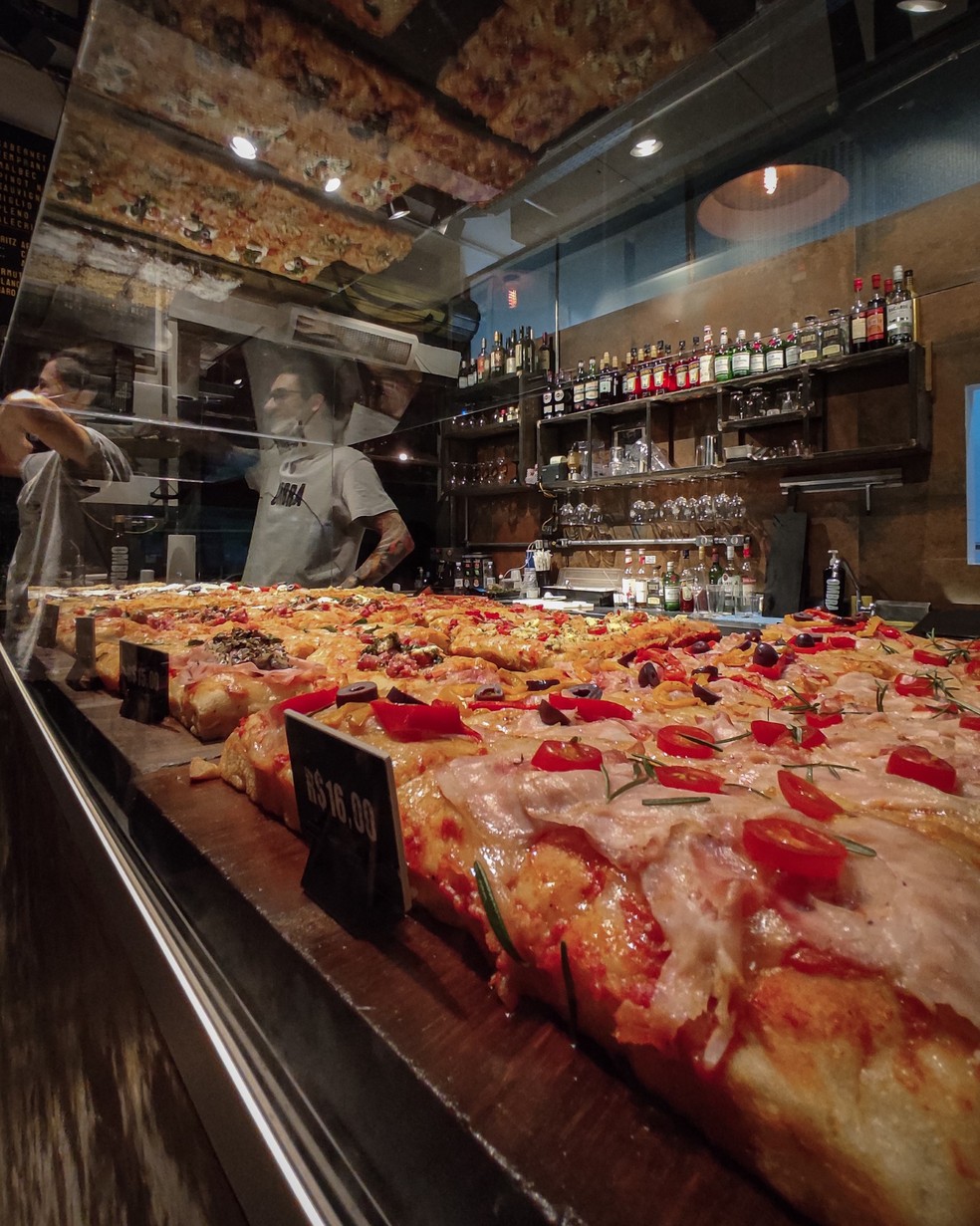 Le pizze alla romana vengono esposte sul bancone e finite in forno quando arrivano gli ordini - Immagine: Informativa
